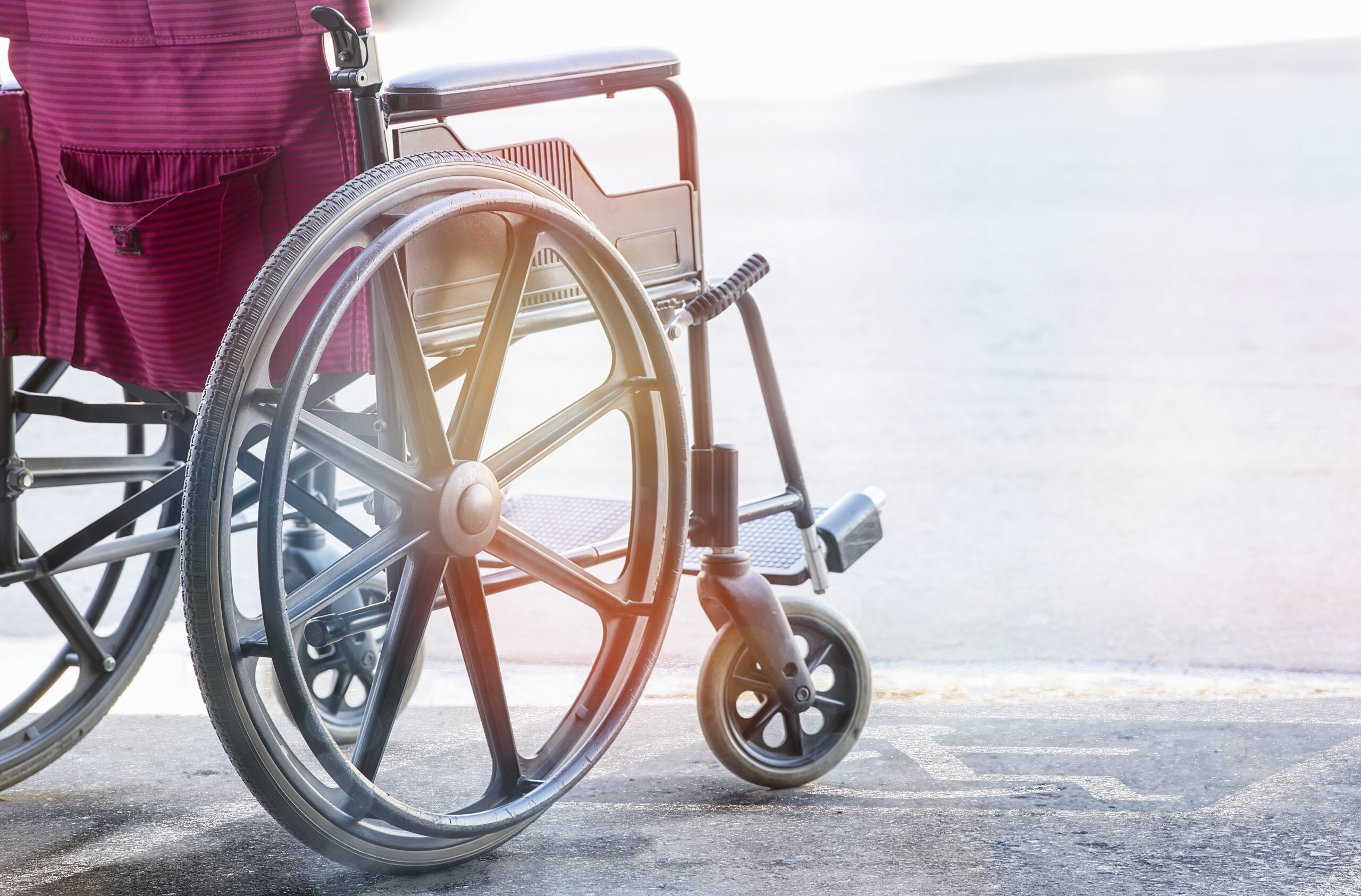 close up view of empty wheelchair with Pavement handicap symbol